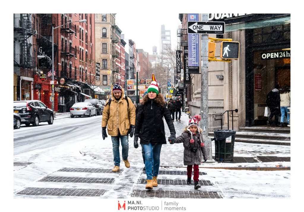 Una famiglia passeggia  per le strade di New York City dopo una tempesta di neve