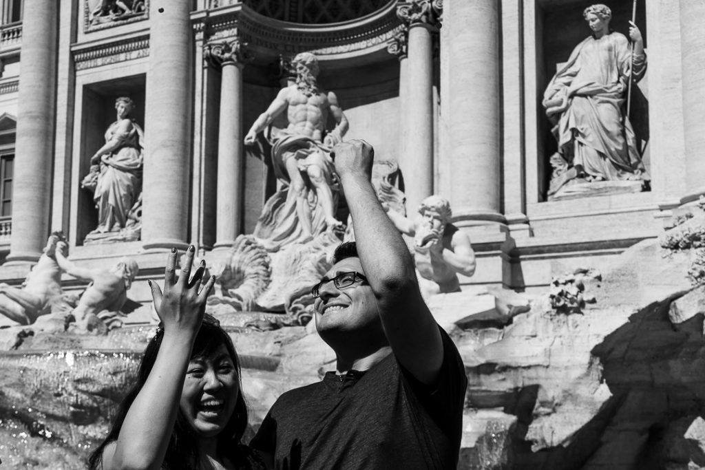 giovane coppia lancia una monetina nella Fontana di Trevi