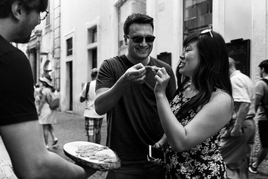 giovane coppia brinda con una fetta di salame a roma