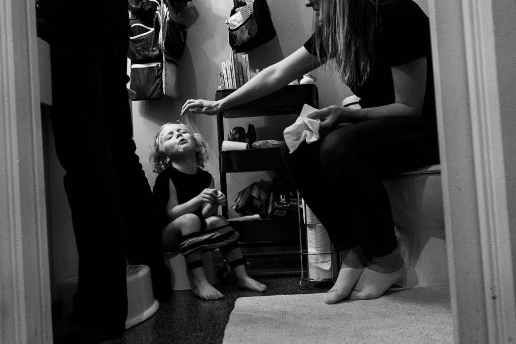 Fotografia documentaria di famiglia la madre consola la figlia mentere è sul vasino
